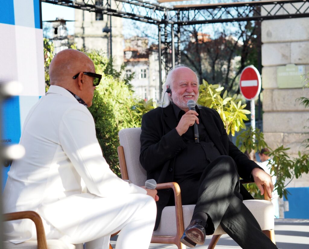 Writer László Krasznahorkai speaking with the host on an outdoor stage during the Babell literary festival.